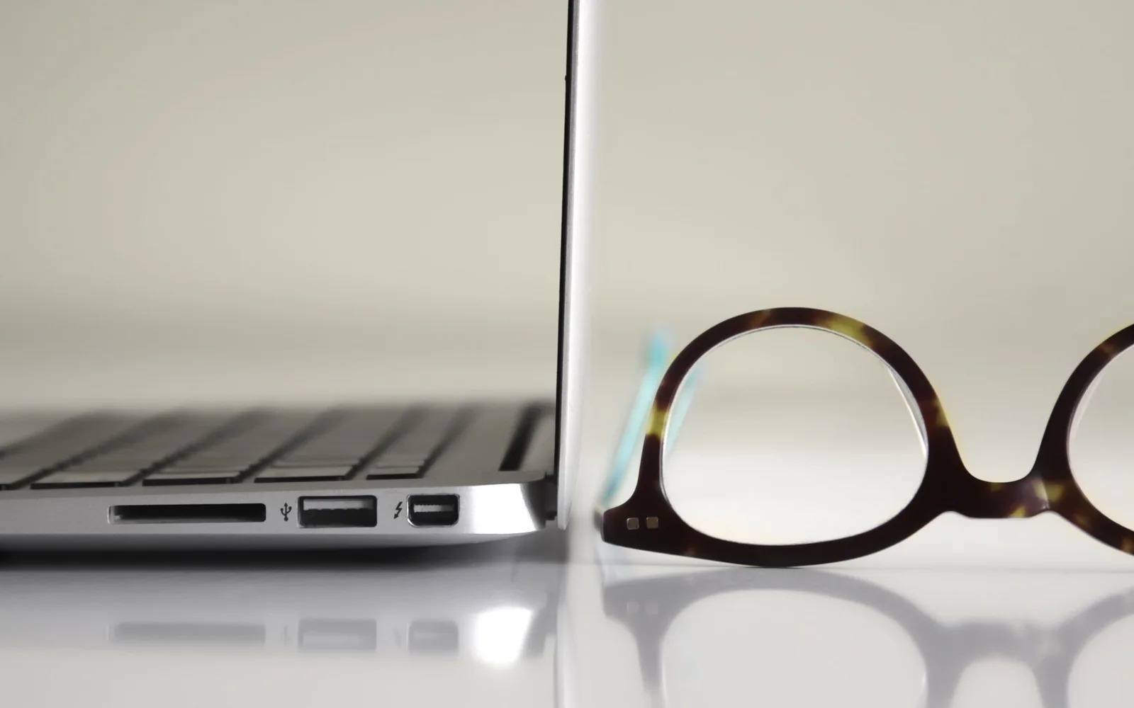 Ochelari lângă un laptop, într-un spațiu de lucru